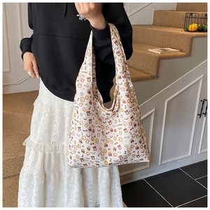 Detail of white tote bag featuring cute cartoon bear prints and textured fabric finish