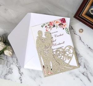 Detail of laser-cut glitter gold wedding invitation featuring Mr & Mrs silhouette and floral insert