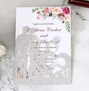 Detail of silver glitter laser cut wedding invitation with Mr & Mrs design on marble background