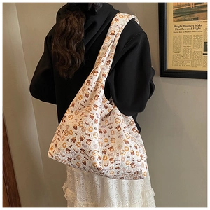 Detail of white seersucker tote bag with cute bear patterns shown on model shoulder