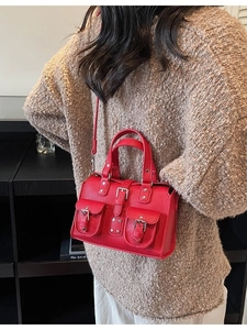 Red lychee pattern crossbody bag with decorative pockets and silver hardware on a model