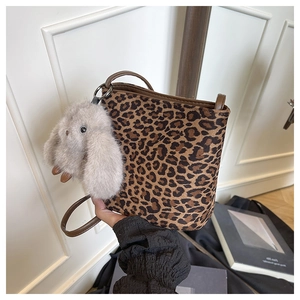 Dettaglio della borsa a secchiello leopardata con ciondolo a coniglio in peluche grigio