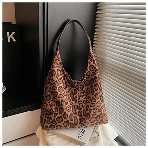 Macro detail of high-capacity leopard print tote bag with brown slim shoulder strap