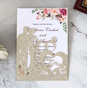 Close-up of laser-cut glitter paper wedding invitation with Mr & Mrs heart silhouette