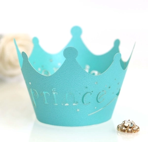 Detail of turquoise laser-cut cupcake wrappers with Prince text and star cutout design