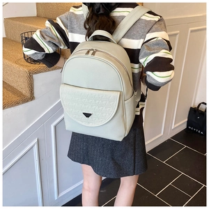 Detailed side view of light green leather travel backpack with triangular quilting detail