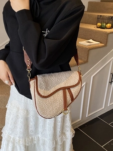 Chic sherpa saddle bag with brown leather trim and gold hardware worn by model