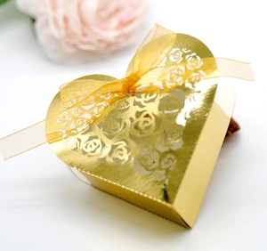 Detailed view of laser-cut rose patterns on a gold heart-shaped wedding favor gift box