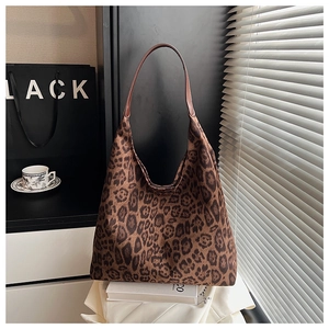 Detailed view of large leopard print tote bag styled with city life props and natural light