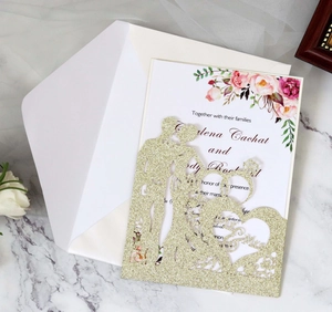 Detail of laser-cut gold glitter wedding invitation with Mr & Mrs silhouette and inner card
