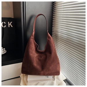 Detail of a large brown suede hobo bag with vintage texture and sleek minimalist design