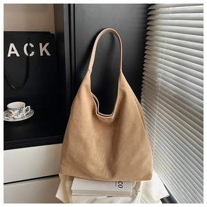 Macro shot of camel suede hobo tote bag featuring minimalist texture and spacious interior