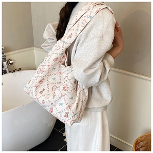 Detail of quilted waffle fabric shoulder bag with cute cartoon bear and heart patterns
