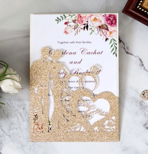 Detail of laser cut champagne gold glitter wedding invitation with Mr & Mrs motif