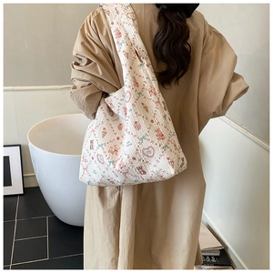 Quilted tote bag with cartoon prints shown on model for size and style reference
