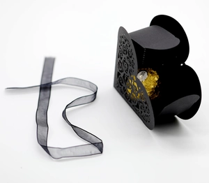 Detail of black laser-cut heart gift box with rose patterns and black organza ribbon