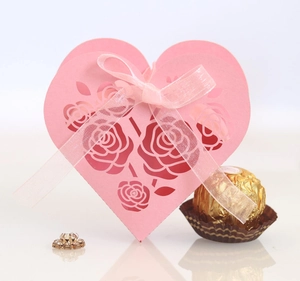 Pink heart-shaped laser-cut favor box with rose patterns and a matching ribbon bow