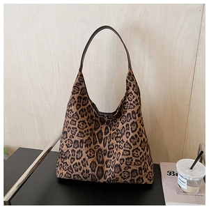 Macro shot of large leopard print hobo shoulder bag with a brown strap on a table