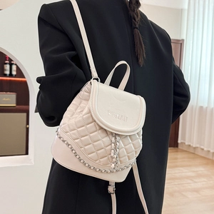 Close-up of beige quilted leather backpack with silver chain detail and WDMAN logo