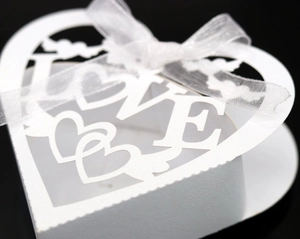 Detail of laser-cut heart candy box with LOVE motif and white organza ribbon bow