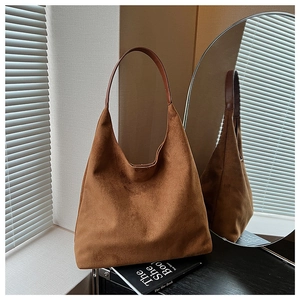 Detailed close-up of brown suede hobo tote bag with leather straps and soft texture