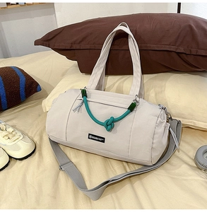 Detail der Canvas-Reisetasche mit grünem Seilakzent und verstellbarem Gurt auf dem Bett