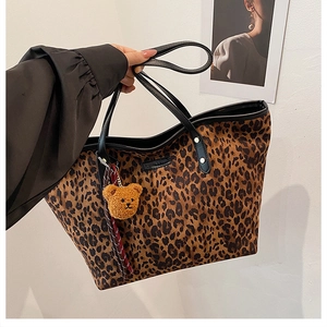 Detailansicht der Leopard-Print Shopper Tasche mit schwarzen Henkeln und Bären-Anhänger