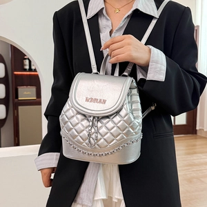 Detail of silver quilted backpack with drawstring and metal chain decoration