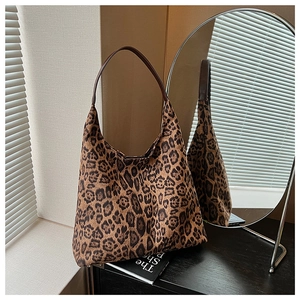 Detailed view of leopard print tote bag with brown leather handle and spacious interior