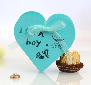 Blue heart-shaped favor box with It's a boy cutout design and ribbon for baby shower