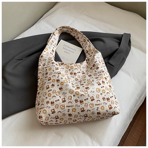 Detailed texture of beige puffy tote bag featuring cute cartoon bear and toast patterns