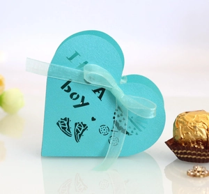 Blue heart-shaped favor box with It's A Boy text and ribbon for baby shower parties