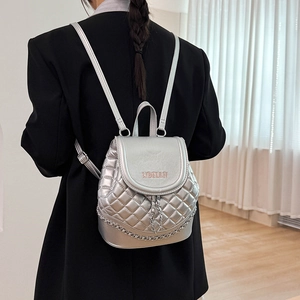Detail of silver quilted mini backpack with WOMAN embroidery and metal chain strap