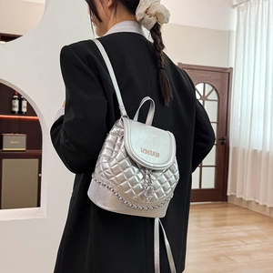 Detail of silver quilted bucket backpack with chain strap and embroidered woman text