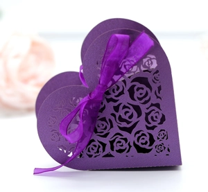 Detail of laser-cut rose patterns on a purple heart-shaped gift box with silk ribbon