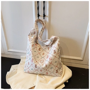 Detail of seersucker tote bag with bear and strawberry patterns on a cream fabric