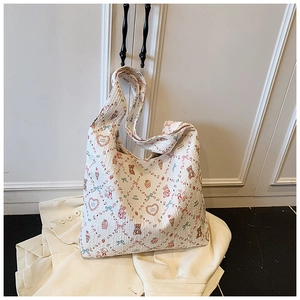 Close-up of quilted tote bag featuring floral bear patterns and sweet strawberry motifs