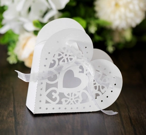 Détail du motif cœur découpé au laser sur boîte à dragées blanche avec ruban chic