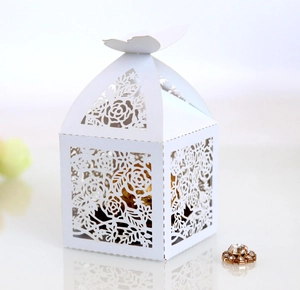 Detail of laser-cut ivory butterfly candy box with elegant rose floral hollow patterns