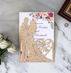 Detail of laser-cut gold glitter wedding invitation with Mr & Mrs silhouette and floral insert