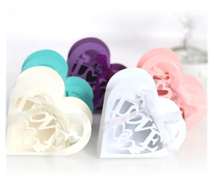 Laser-cut heart wedding favor boxes with LOVE text and ribbon bows in various colors