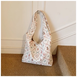 Detail of soft cream tote bag with cute bear, strawberry and heart patterns on stairs