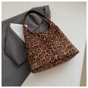 Detail of hobo tote bag with leopard print texture and brown leather shoulder strap