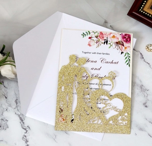 Detail of glitter gold laser cut wedding invitation with floral insert and white envelope