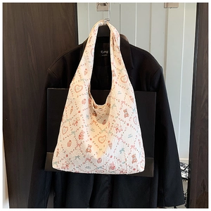Detail of white pleated tote bag with cute bear, strawberry and heart cartoon patterns