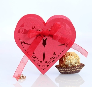 Detailed laser-cut heart candy box in red with elegant floral patterns and a silk ribbon