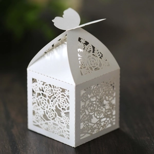 Detail of laser-cut rose patterns and butterfly clasp on white pearl paper candy box