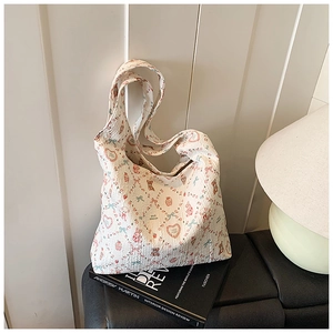 Detail of white quilted tote bag with cute cartoon patterns on a black leather seat