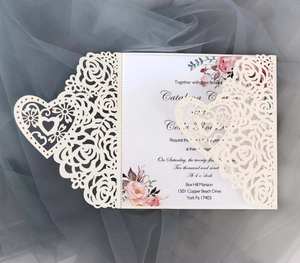 Detail view of laser-cut rose and heart wedding invitation with floral insert
