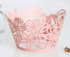 Elegant laser-cut light pink cupcake wrappers with hollow floral and leaf patterns